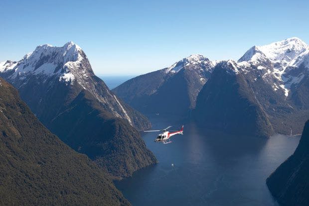 Helicopter flying over Milford Sound in New Zealand