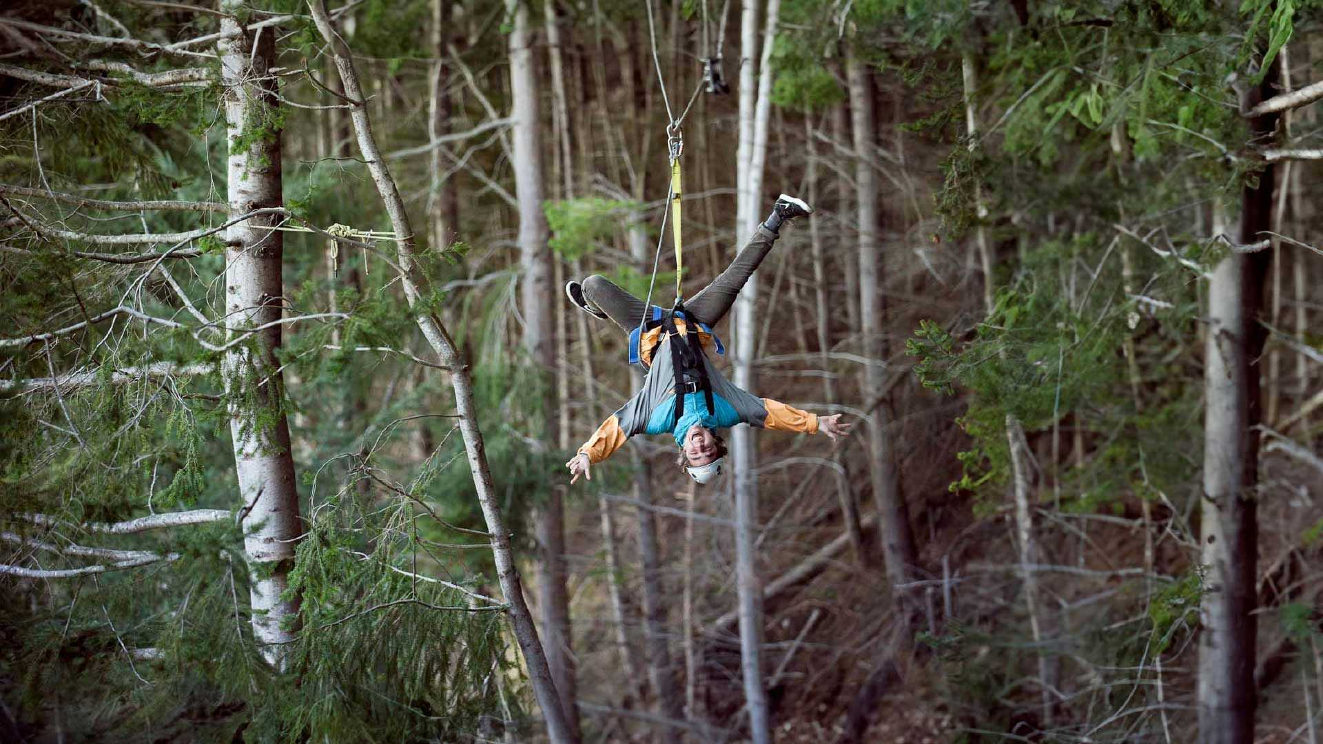Person hanging upside down on a zipline