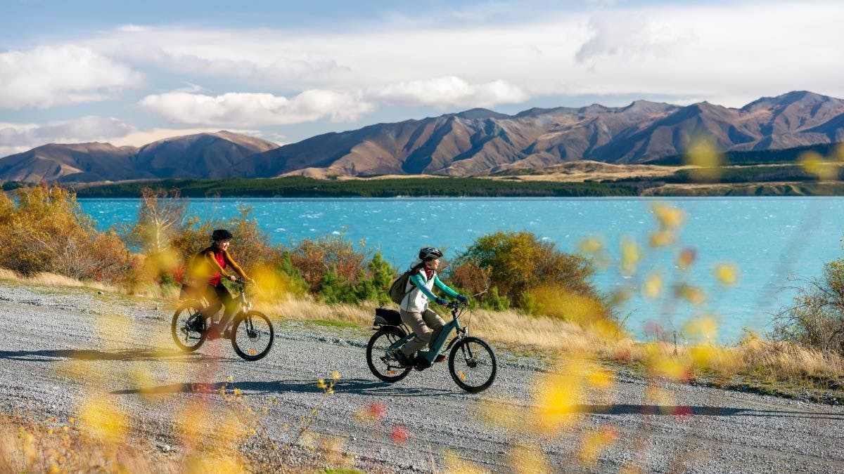 Two people cycling next to Lake Tekapo in New Zealand
