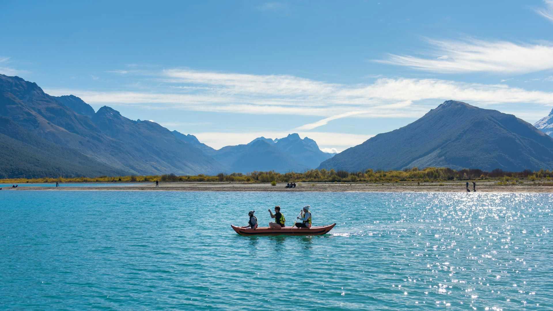 Three people on a kayak in Lake Wakatipu in New Zealand