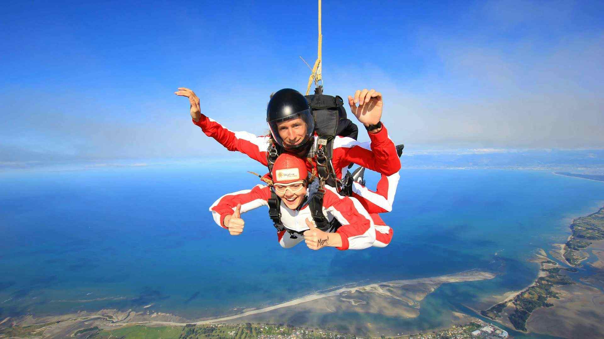 Woman tandem skydiving over Abel Tasman National Park