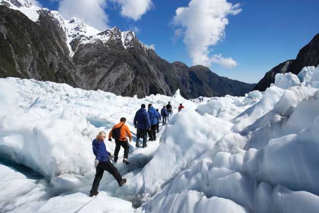 Group of people hike up Franz Josef Glacier