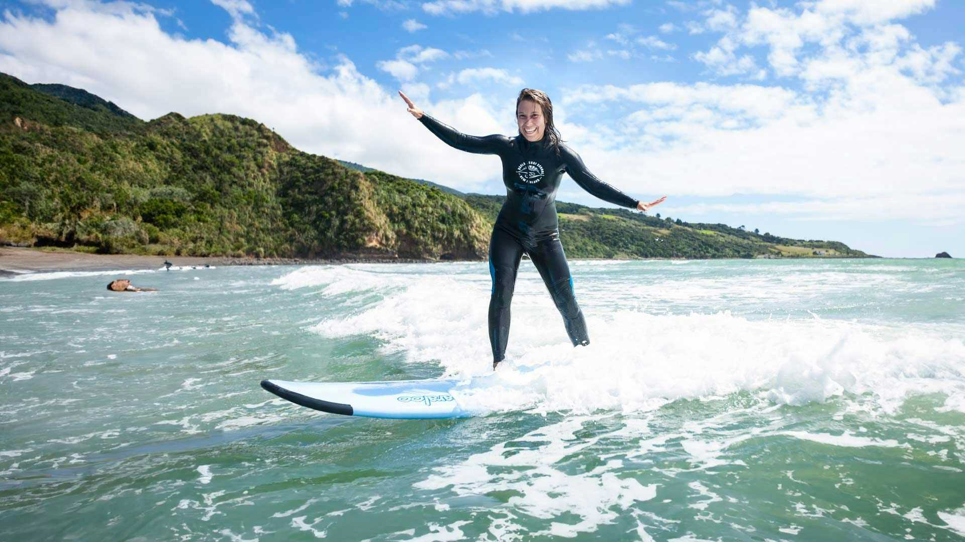 Woman surfing in Raglan