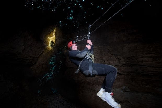 Wild Kiwi guest abseiling through glowworm caves 
