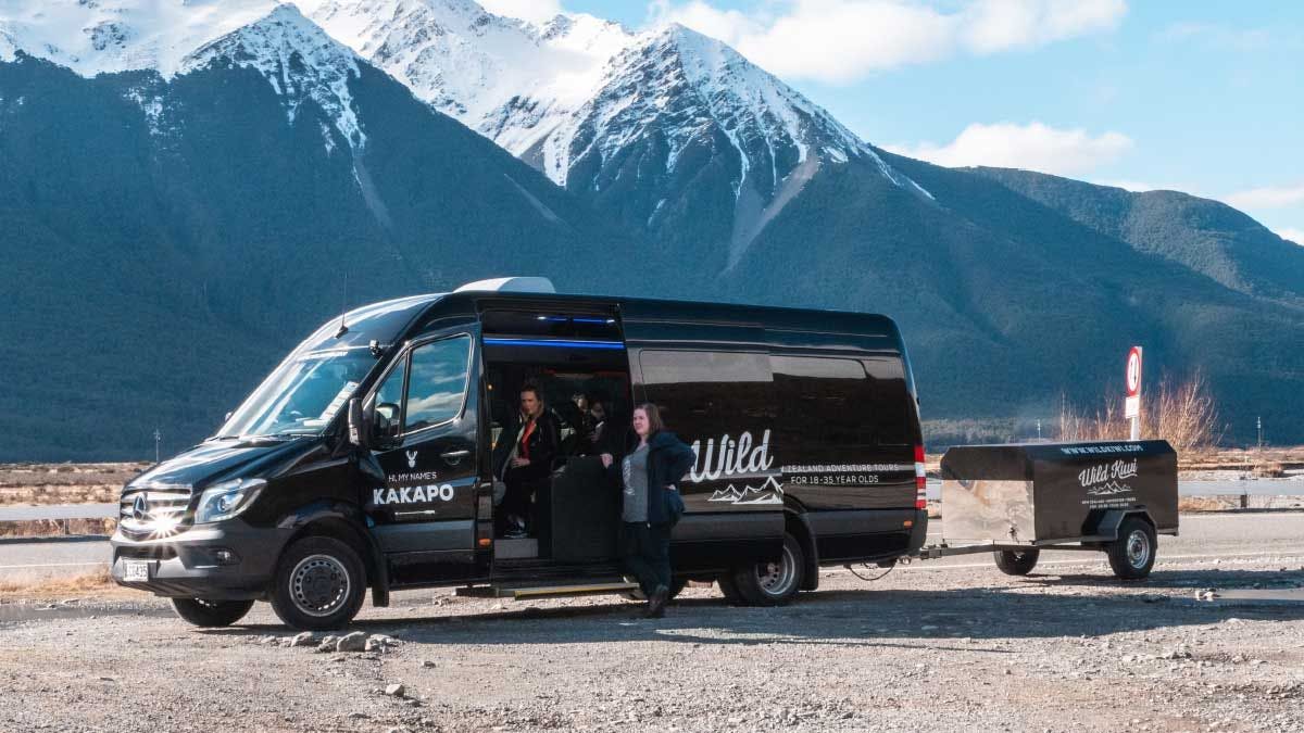 Wild Kiwi tour vehicle parked in front of some mountains