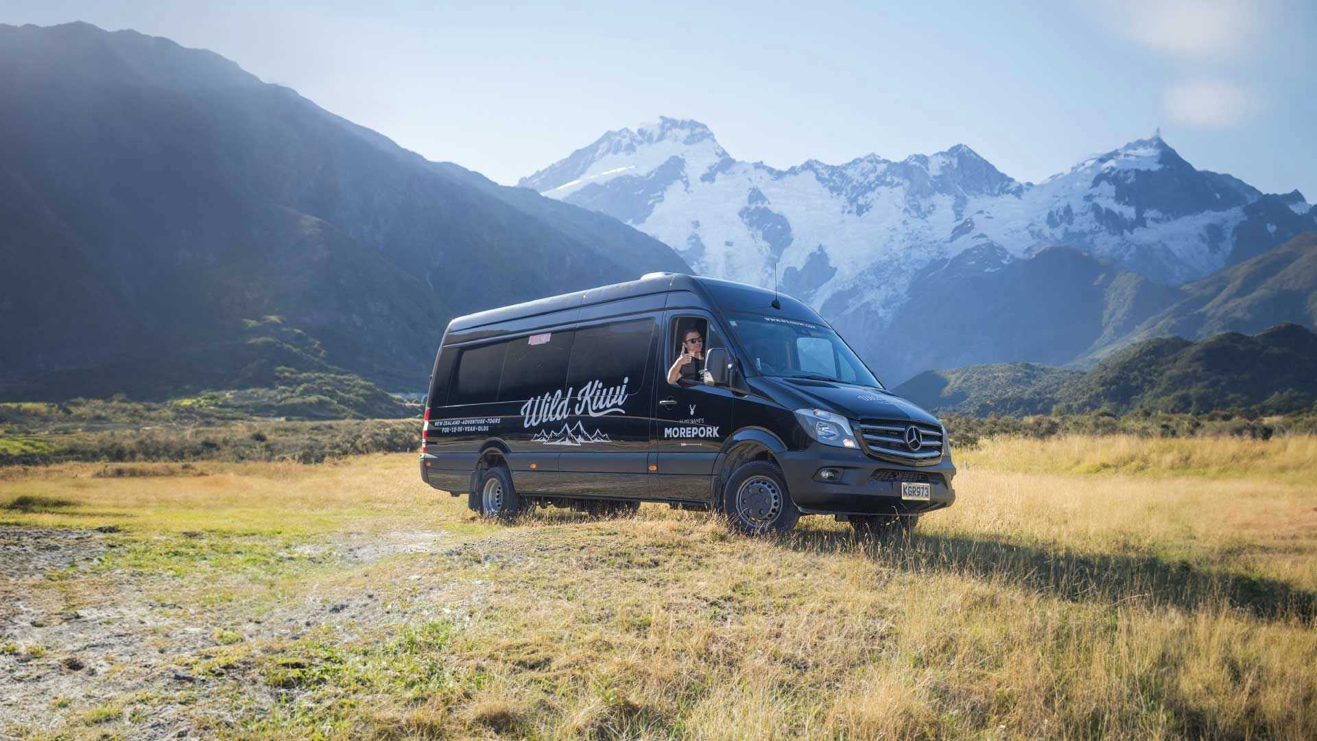 Wild Kiwi vehicle parked in front of some mountains in New Zealand