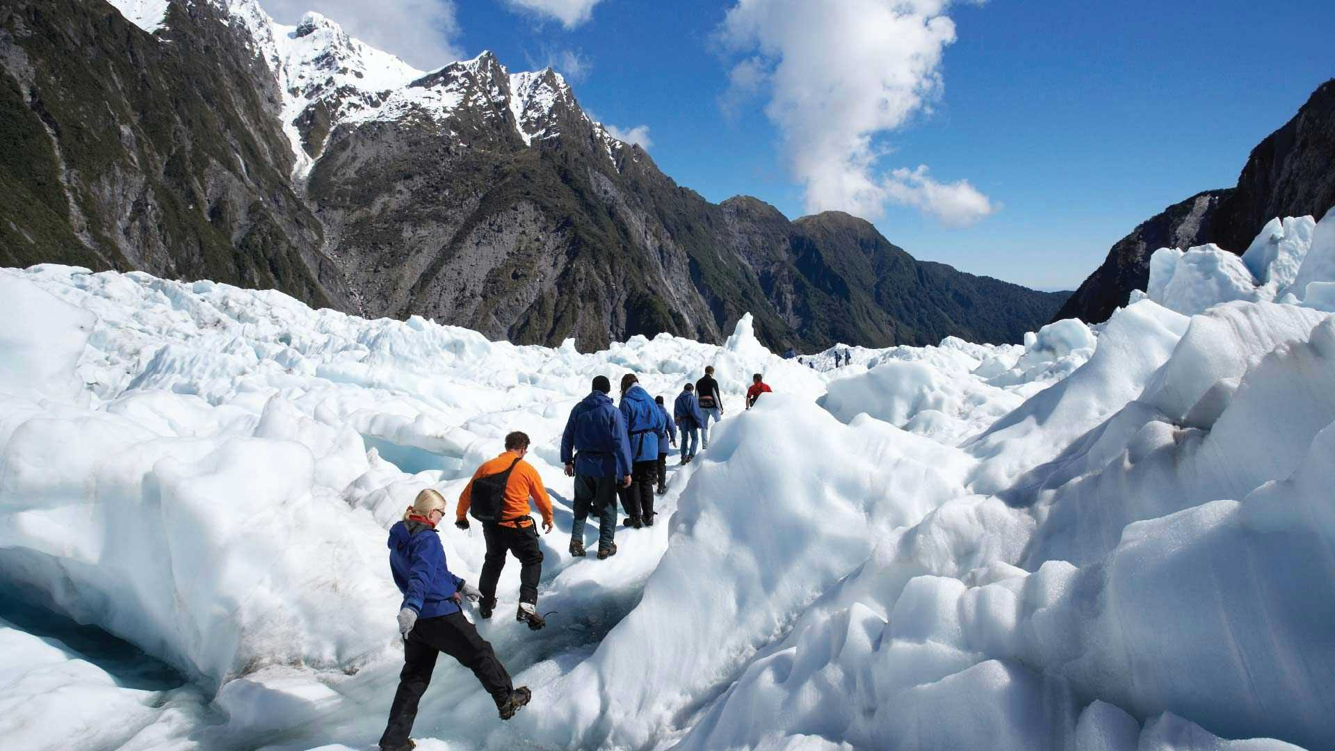 Group of people hiking up Franz Josef Glacier in New Zealand
