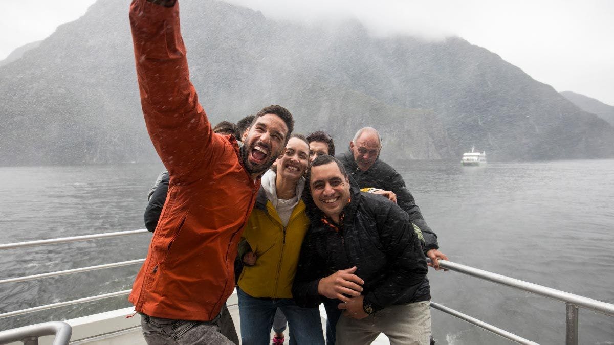 Group of friends pose for a photo on a cruise in Milford Sound