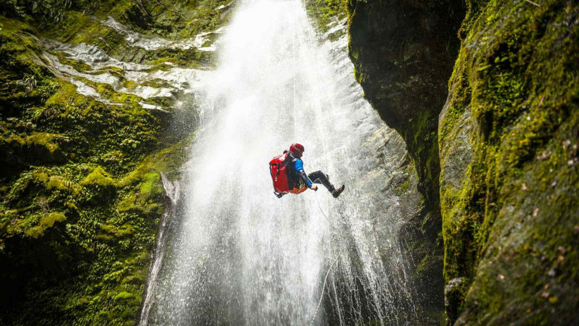 Person abseiling down a waterfall