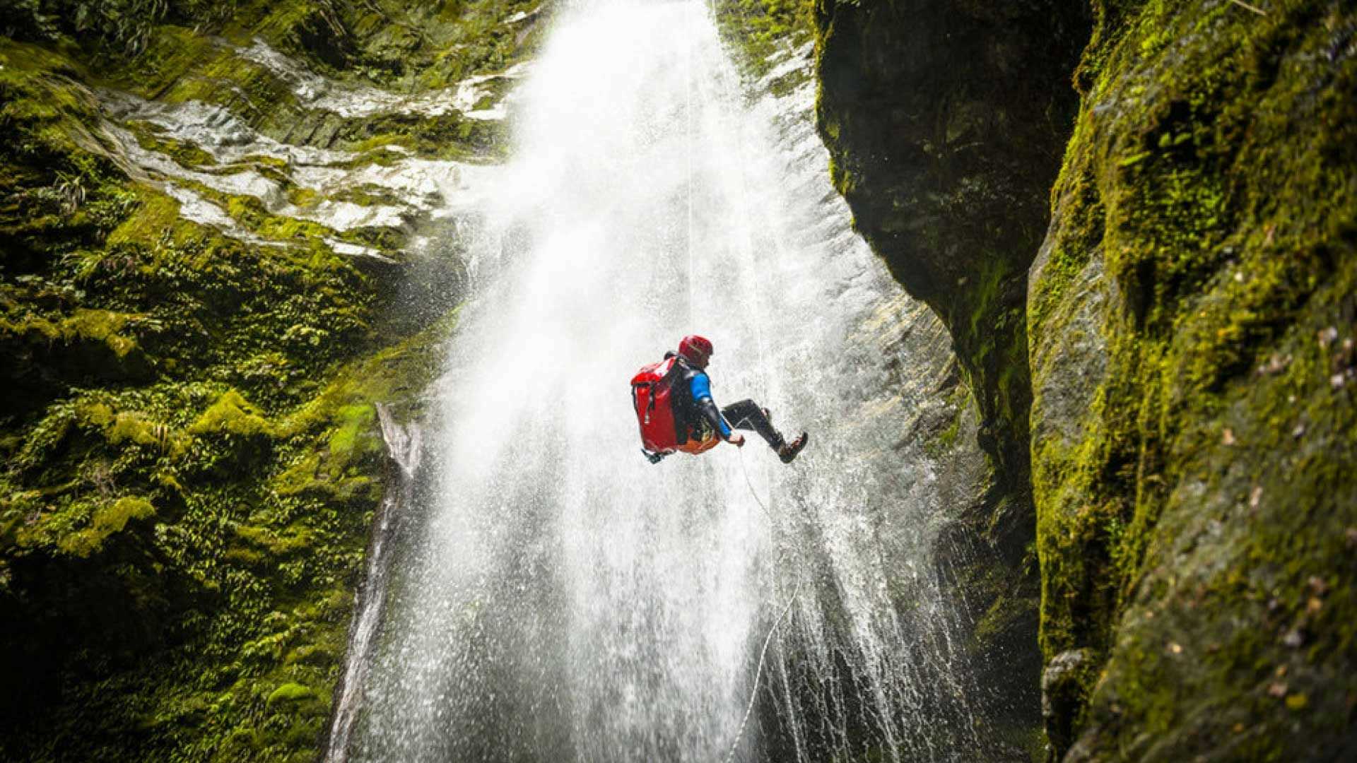 Person abseiling down a waterfall