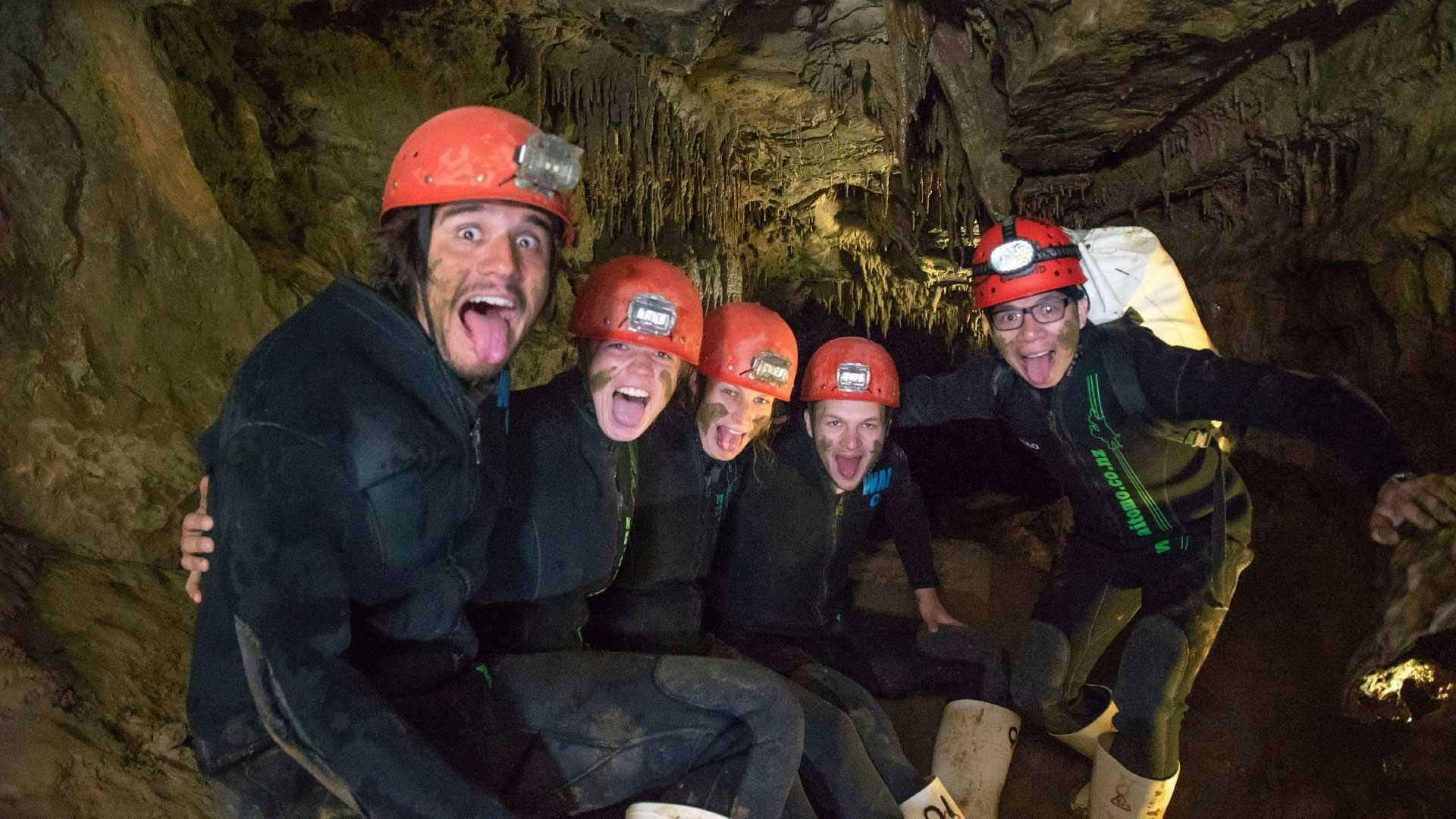 Group of people pose for a photo in a cave