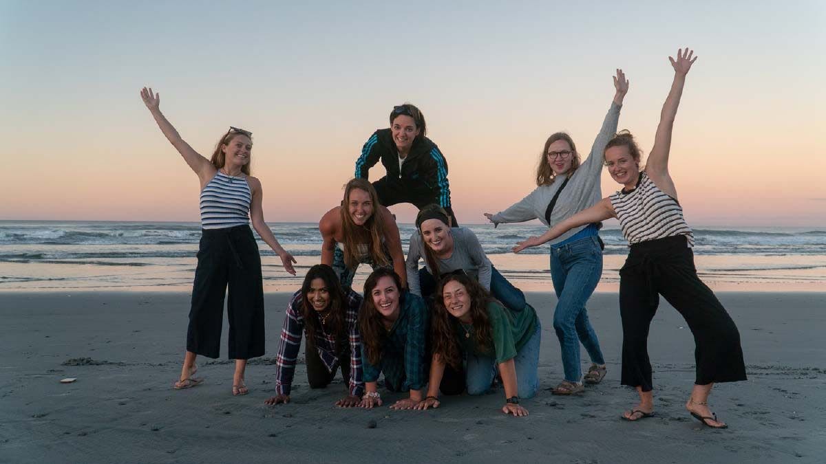 Group of friends posing for a photo on the beach at sunset