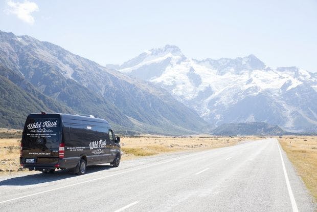 Wild Kiwi vehicle in front of mountain landscape