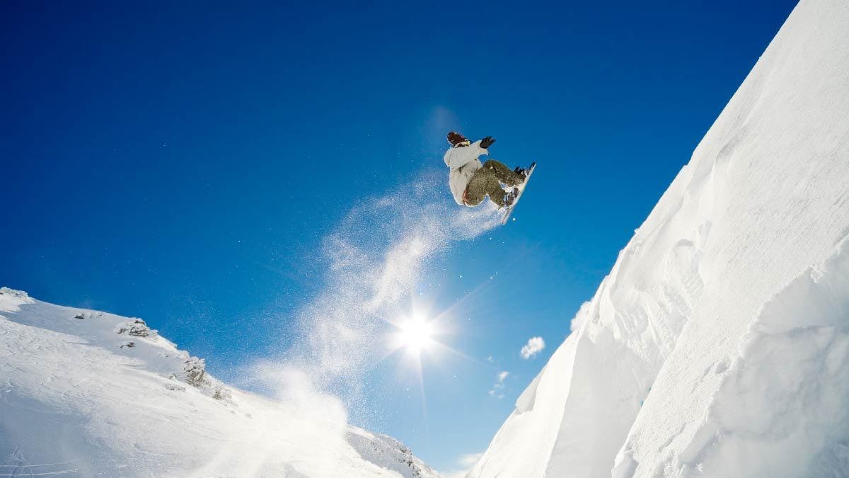 Man doing a jump on his snowboard 