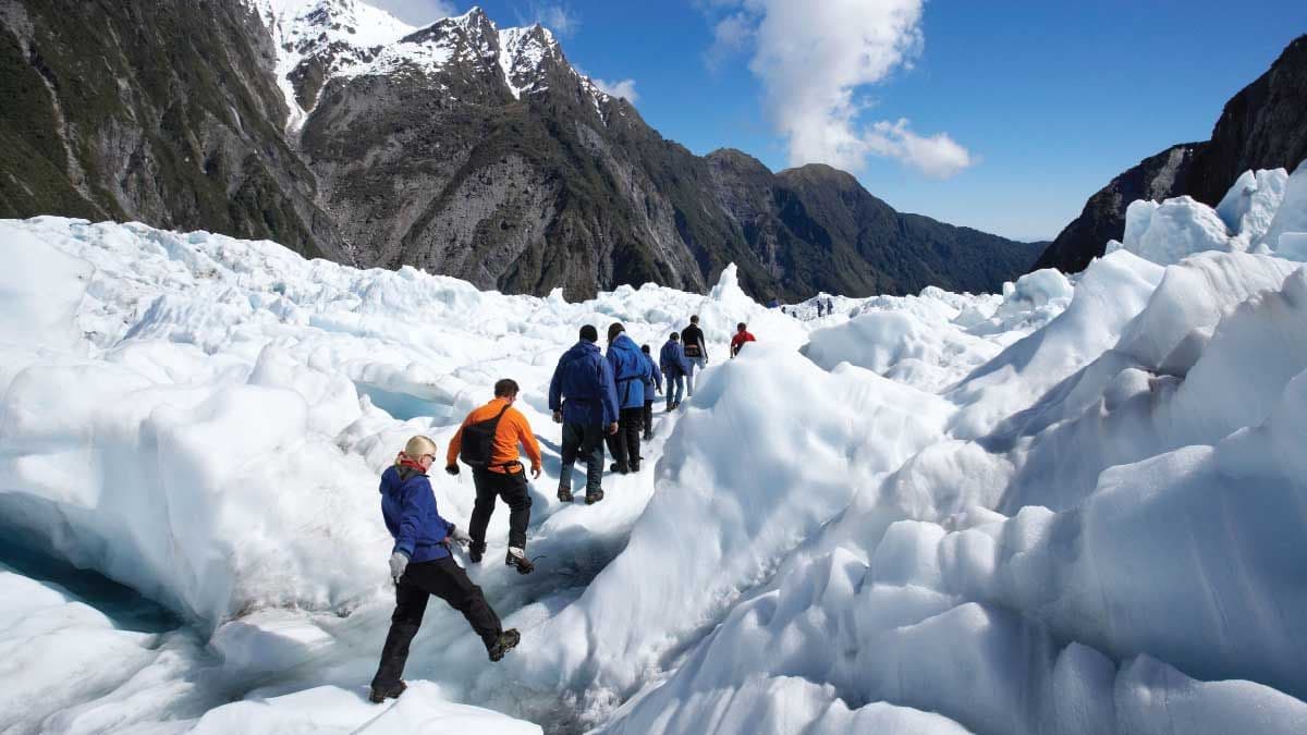 Group of people hiking up Franz Josef Glacier