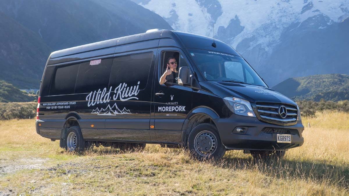 Wild Kiwi Tour vehicle parked on some grass in New Zealand