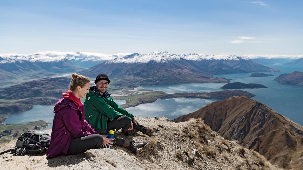 Couple sitting together on Roys Peak in New Zealand