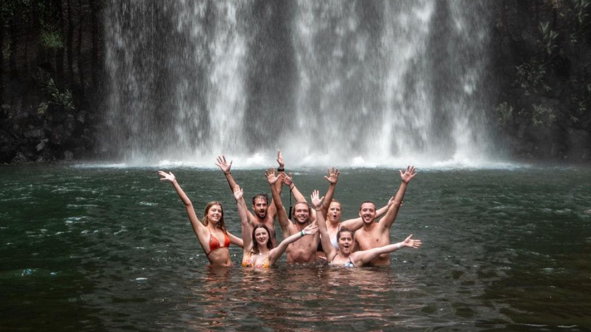 Group of people swimming in a waterfall